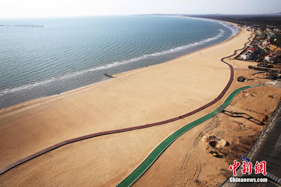 3月13日，秦皇島萬米臨海沙灘木棧道。據(jù)了解，該木棧道全長(zhǎng)約4200米，與北戴河區(qū)原有的7500米木棧道對(duì)接后全線總長(zhǎng)度1.17萬米，整個(gè)木棧道東起秦皇島體育基地游船碼頭，西至北戴河濕地公園，呈波浪形蜿蜒10.4公里海岸線。 中新社發(fā) 曹建雄 攝 CNSPHOTO